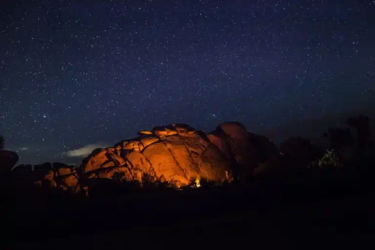 Starry night over illuminated rock formation