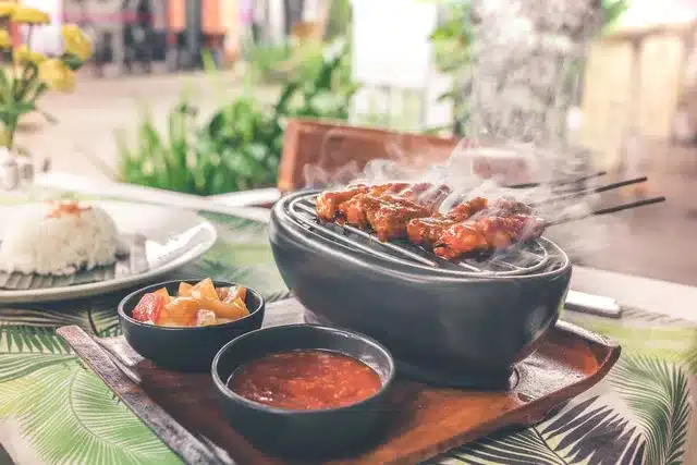 Sizzling grilled chicken wings in a clay pot