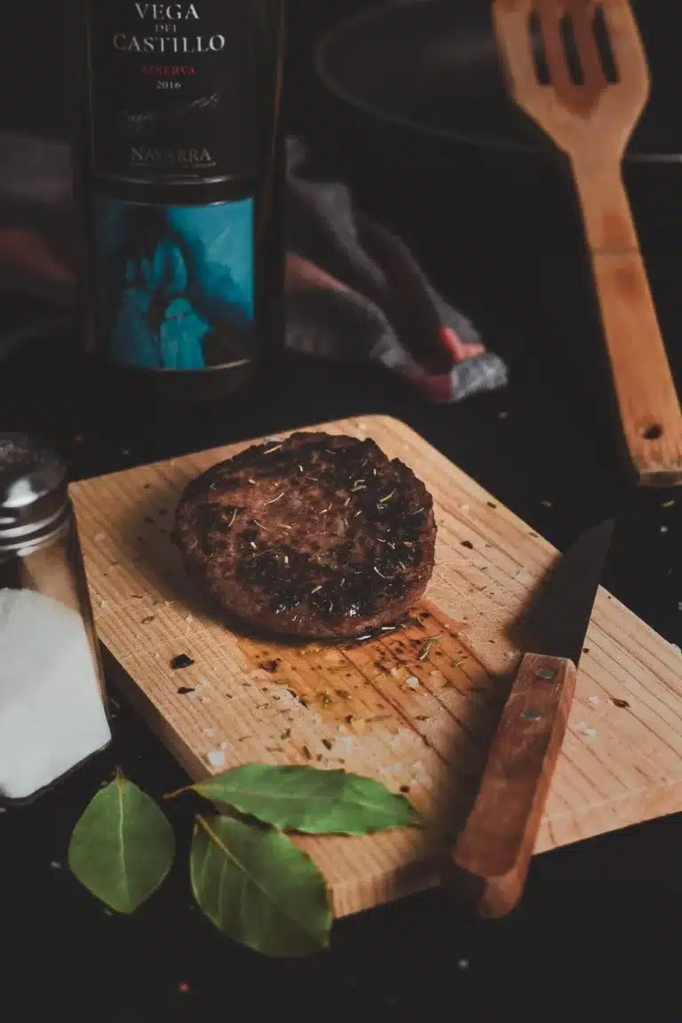 Grilled steak on a wooden board with seasonings