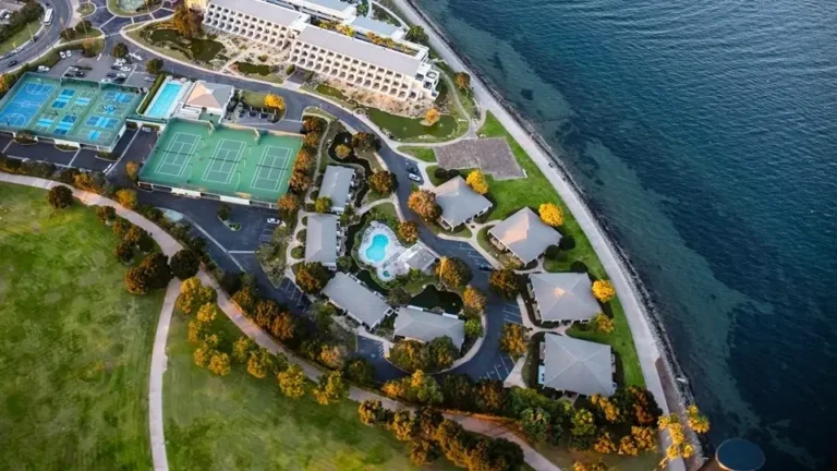 Aerial view of Coronado with coastal resort facilities, tennis courts, and scenic ocean shoreline.