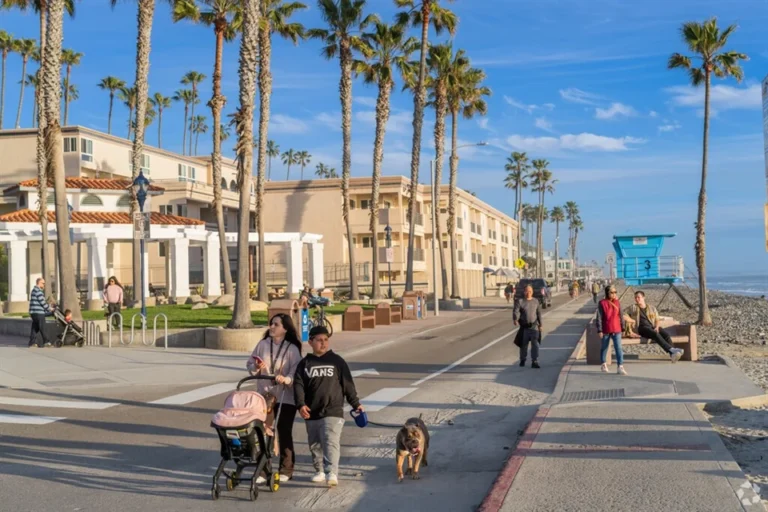 Families strolling along the Downtown Oceanside boardwalk, enjoying the sunshine and beach views.