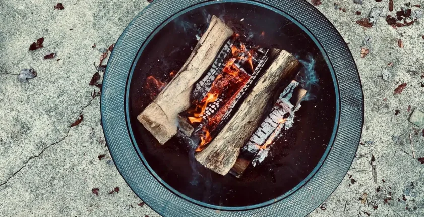 Wood logs burning in an outdoor fire pit